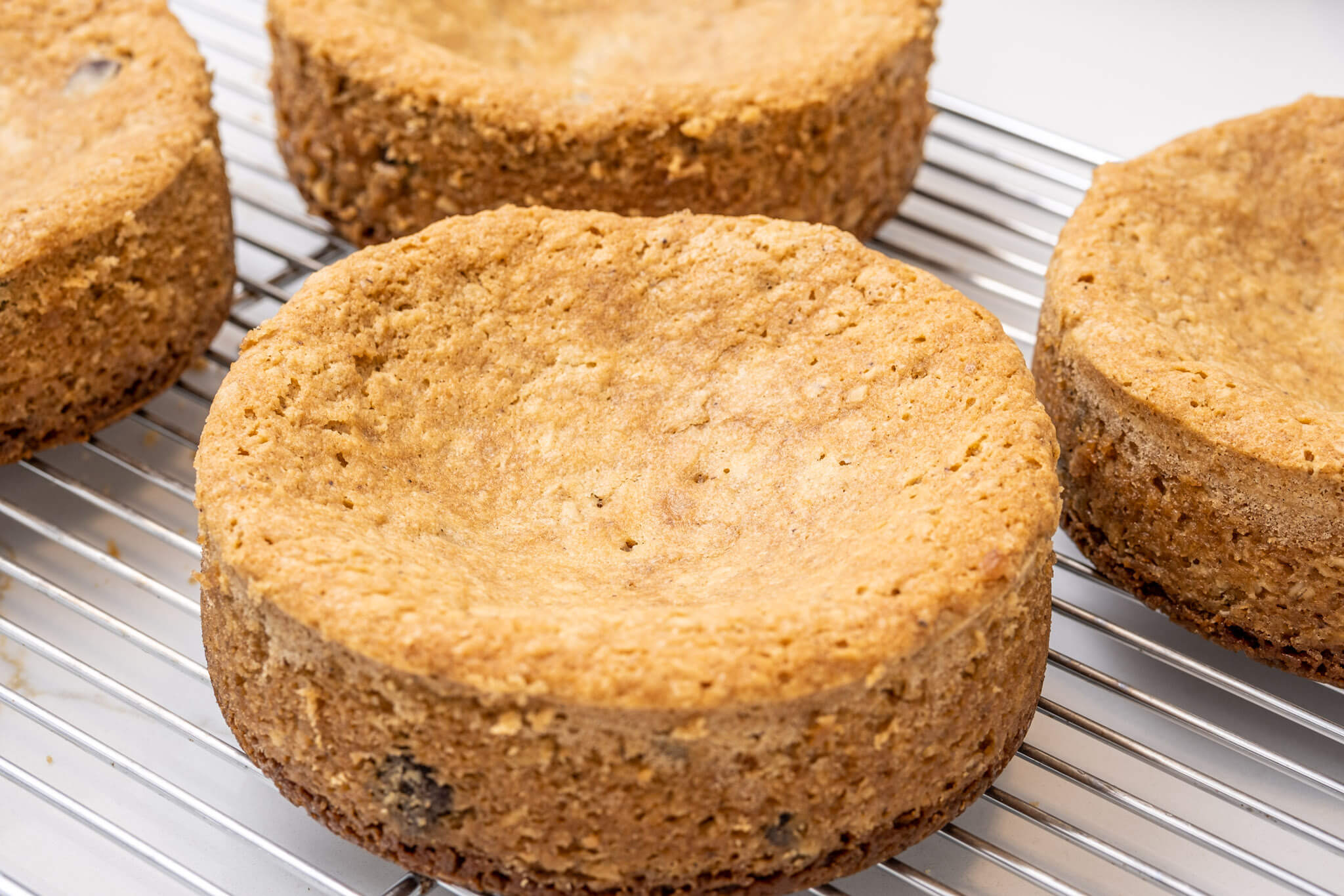 Four cake layers on a cooling rack, for making into a 6-inch layer cake