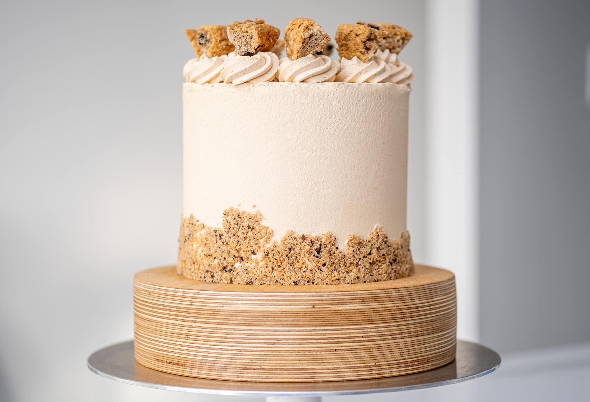 Vegan layer cake with Biscoff-flavoured buttercream icing and decorated with chunks and crumbs of oatmeal-chocolate cake.