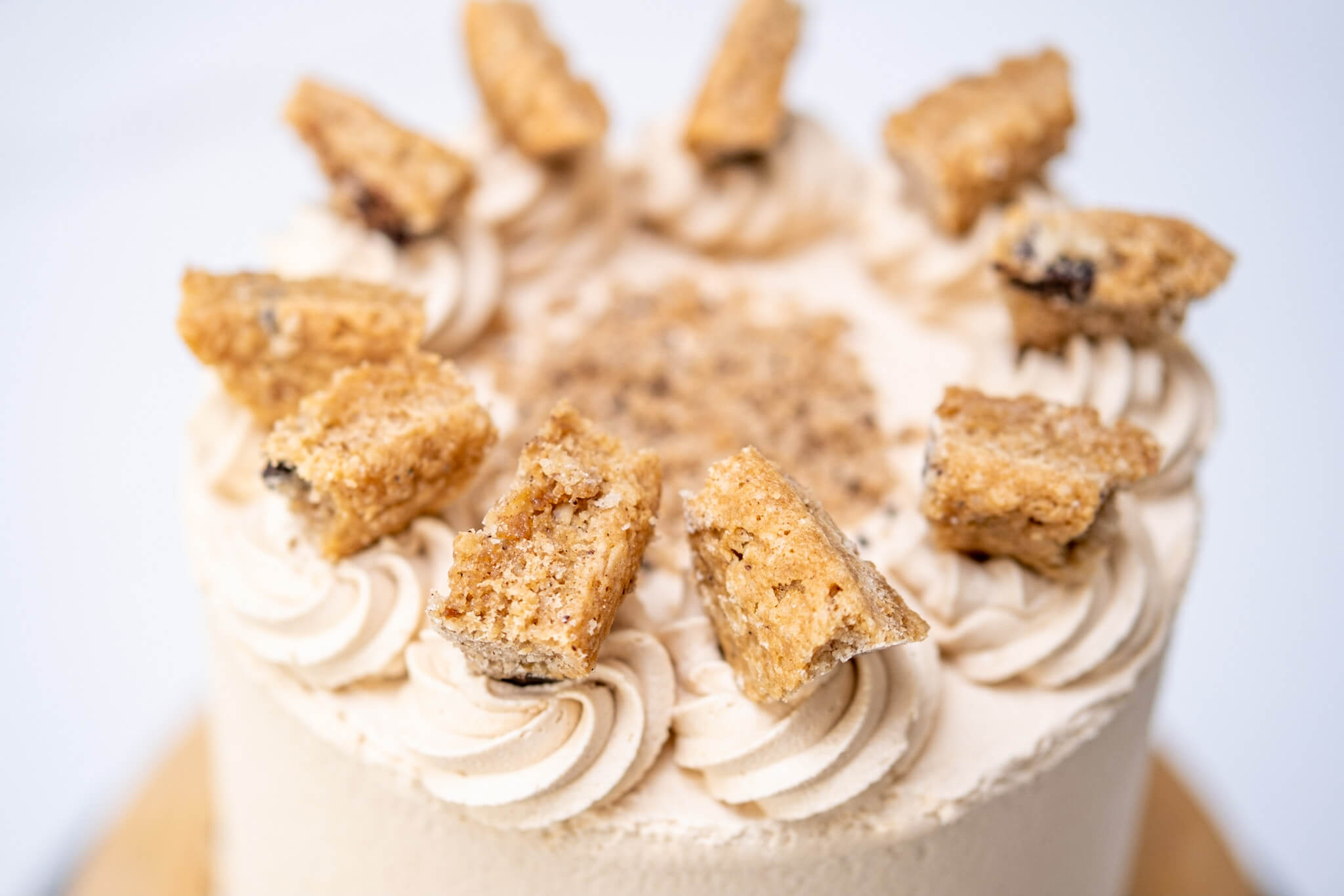 Top of a cake decorated with buttercream rosettes, cake chunks and cake crumb