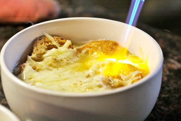 Using a blow torch to melt and brown the cheese