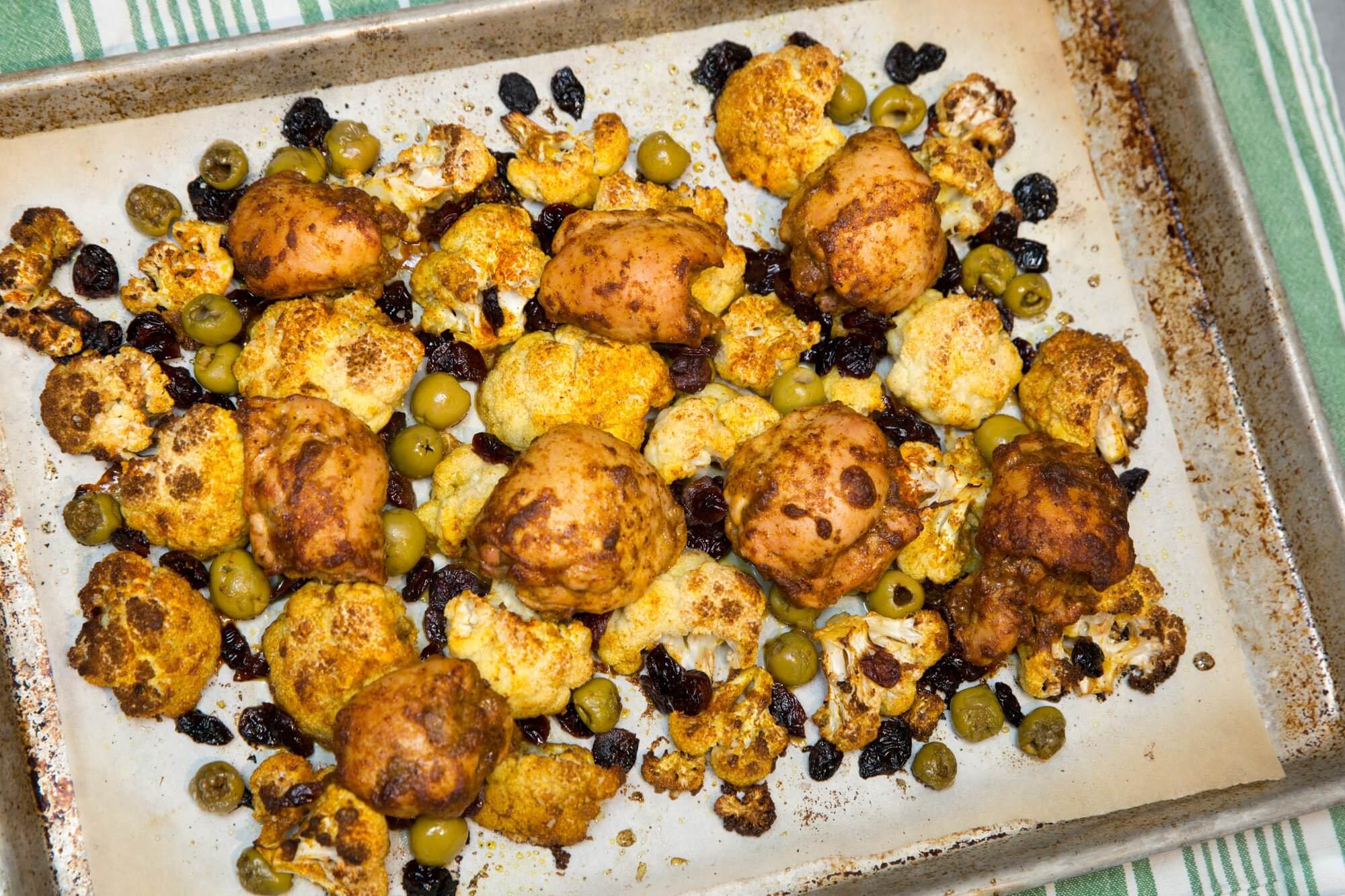Curried chicken thighs with cauliflower, dried cranberries and olives