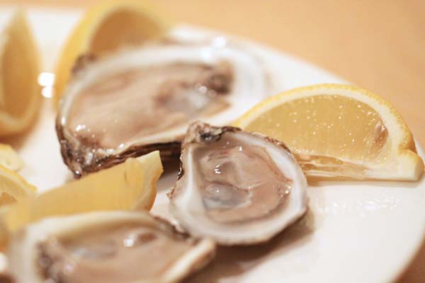 Shucked oysters with lemon wedges